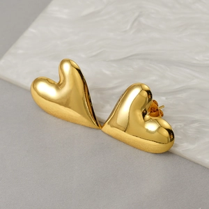 Polished 18K gold plated heart stud earrings in stainless steel on white textured base