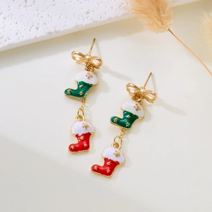 Detail of Christmas bow earrings with red and green enamel stocking pendants on white stones