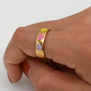 Detail of 18K gold plated wide ring featuring colorful enamel heart patterns