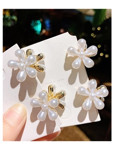Vue détaillée de quatre mini pinces à cheveux fleur en perles avec base dorée sur carte
