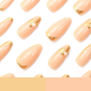 Elegant almond press-on nails with golden gilding and pearl accents on nude pink base