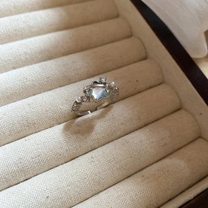 Macro detail of silver star ring with inlaid moonstone, pearls and pavé diamonds