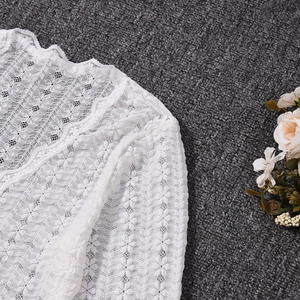 Detailansicht der weißen Spitze mit filigranen Blumenmustern und feiner Stickerei