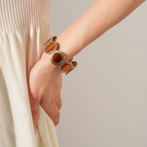 Close-up of retro leopard-style bracelet with amber resin insets on a gold metal band