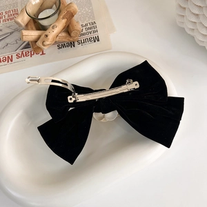 Détail du dos d'une pince à cheveux nœud en velours noir avec clip en métal argenté
