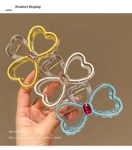 Detailed view of three acrylic hair claws in yellow, clear and blue with gemstone accents
