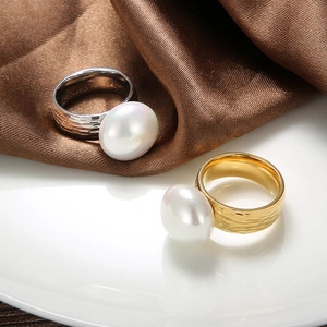 Detailed view of baroque pearl rings with hammered metal texture in gold and silver finish
