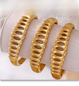 Detail of three gold fishbone bracelets featuring premium PVD electroplating finish