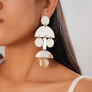 Dettaglio di orecchini geometrici in argento su modella con forme circolari astratte