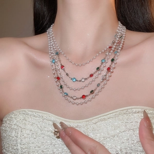 Gros plan d'un collier de perles à cinq rangs avec pierres précieuses sur un mannequin