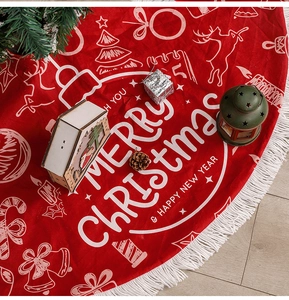Close-up of red Christmas tree skirt with white tassels and festive holiday print