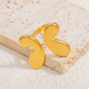 Detailed close-up of a high-polish 18k gold butterfly ring on a natural stone base