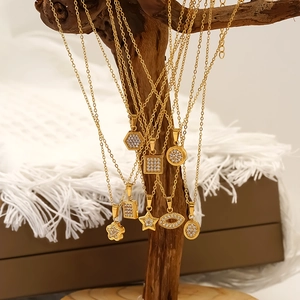 Ensemble de colliers en titane doré avec pendentifs étoile et diamant sur support en bois