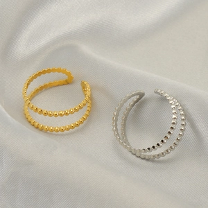 Verstellbarer doppellagiger Perlenring in Gold und Silber auf weißer Seide