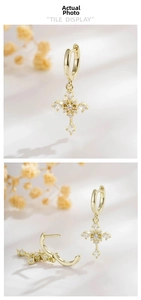 Detailed view of gold cross drop earrings with sparkling zircon inlay and hoop closures