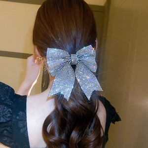 Macro shot of shimmering rhinestones on a large silver bow hair clip for elegant styling