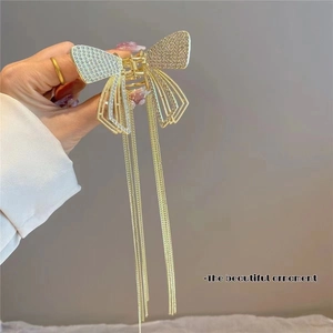 Detail of golden butterfly hair claw with tassel fringe and sparkling rhinestones