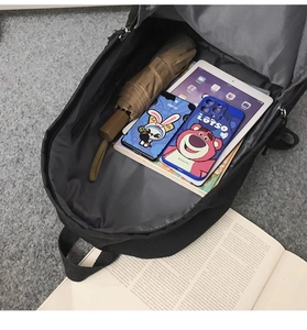 Interior view showing the large capacity of the black backpack with a tablet and umbrella