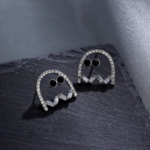 Ghost stud earrings with white zircons and black eyes on a dark stone background