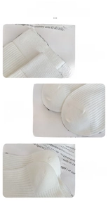 Detail view of white calf socks showing elastic rib cuffs and flat-stitched toe seams