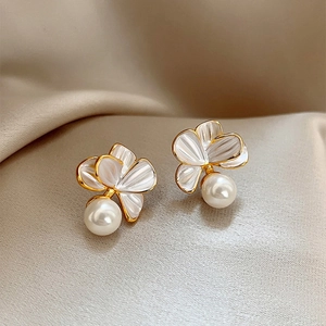 Élégantes boucles d'oreilles fleur dorées avec pétales blancs et perles sur soie