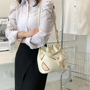 Cream bucket bag with drawstring closure and orange watermelon slice patch design