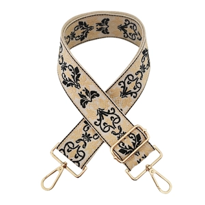 Dettaglio tracolla beige vintage jacquard con motivo barocco e ganci in oro lucido