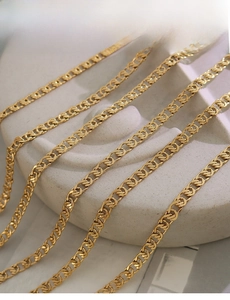 Detail of interlocking 18k gold plated chains with intricate twisted link craftsmanship