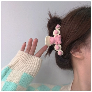 Detail of pink gummy bear and heart hair claw clip on model showing side view hairstyle
