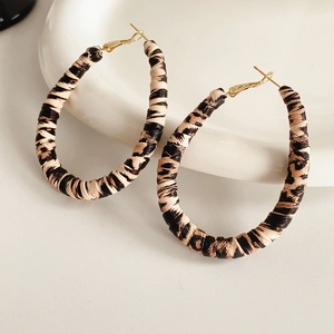 Close-up of leopard print hoop earrings with textured finish and gold hooks