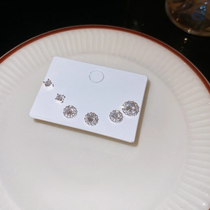 Detailed view of six sparkling round zircon studs on display card set in a ceramic dish