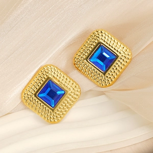Macro shot of 18k gold plated stainless steel square earrings with blue rhinestone gems