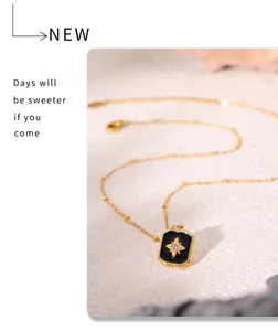 Detail of gold-plated rectangle pendant with black acrylic inlay and star zircon accent