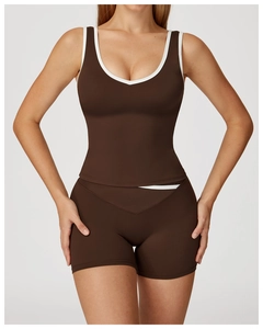 Close-up of brown sports top with white trim and bareback yoga vest detail