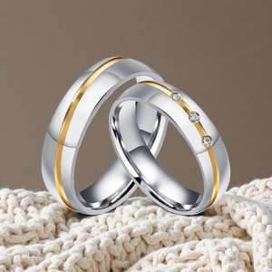 Vue détaillée de bagues de couple élégantes en acier inoxydable bicolore et strass.