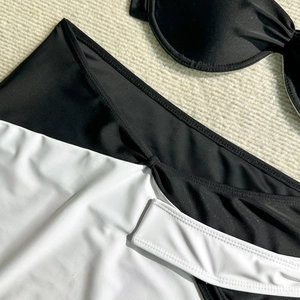Detail of black and white bikini set with knot design on textured knit background
