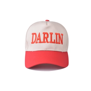 Close-up of three-dimensional red embroidered DARLIN letters on beige cotton baseball cap