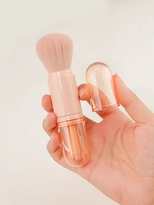 Macro view of portable 4-in-1 makeup brush set with translucent orange capsule handle