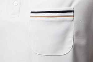 Macro shot of white piqué cotton polo shirt showing striped pocket and fabric texture