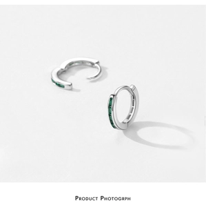 Close-up of S925 sterling silver hoop earrings featuring sparkling green zircon gemstones