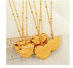 Detailed view of 18K gold plated heart pendant necklaces with small bead chain accents