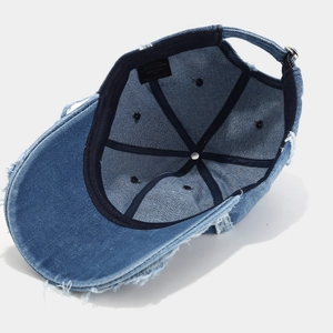 Detailed interior of vintage distressed denim baseball cap showing fabric and wash label