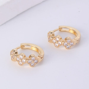 Detailed view of gold plated hoop earrings with three zircon-inlaid clover patterns