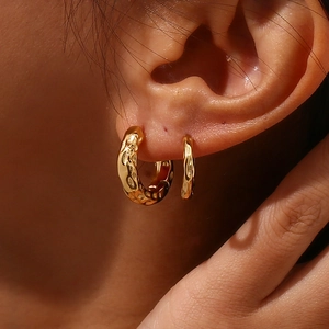Close-up of 18K gold plated stainless steel hoop earrings with irregular lunar texture