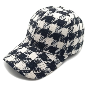 Close-up of black and white houndstooth wool fabric texture on a structured baseball cap
