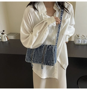 Detail der vintage blauen Denim-Tragetasche mit mehreren Reißverschlussfächern und Gurt