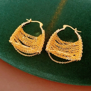 Detail of gold-plated chain drop earrings with sparkling cubic zirconia on green velvet