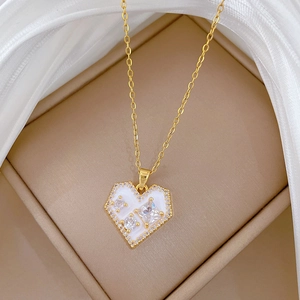 Macro detail of gold heart pendant with zircon stones in a velvet jewelry box