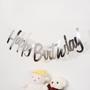 Close-up of silver mirror Happy Birthday banner with cute stuffed animals decoration