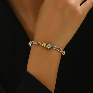 Detail of two-tone braided link bracelet with gold and silver beads on model wrist